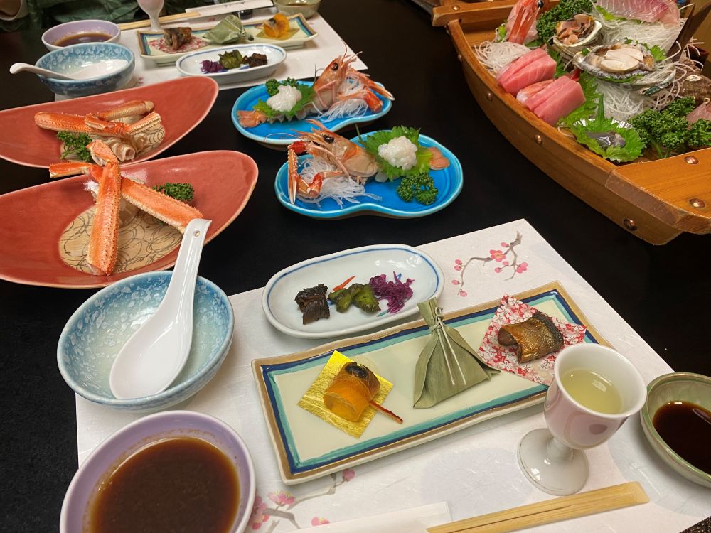 西伊豆・やぎさわ荘の夕食。新鮮な刺身の盛り合わせやエビ料理、豪華な磯料理が並ぶ様子。