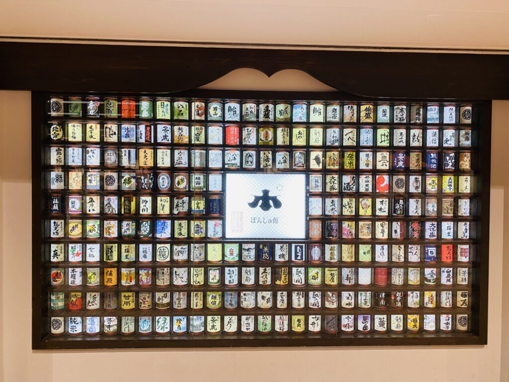 越後湯沢駅構内のぽんしゅ館入り口に展示されている、たくさんの日本酒の銘柄の棚